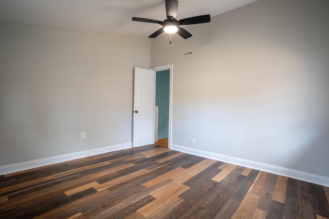 empty room featuring a ceiling fan, dark wood finished floors, visible vents, and baseboards