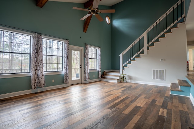 unfurnished living room featuring beamed ceiling, stairway, visible vents, and baseboards