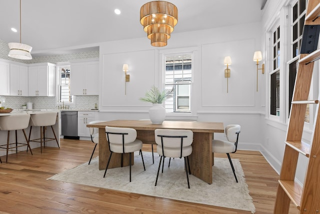 dining area featuring light wood-style flooring and baseboards