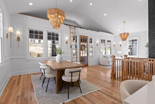 dining area with a chandelier, vaulted ceiling, light wood-style flooring, and recessed lighting