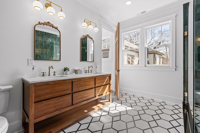 full bath featuring baseboards, visible vents, toilet, ornamental molding, and a sink