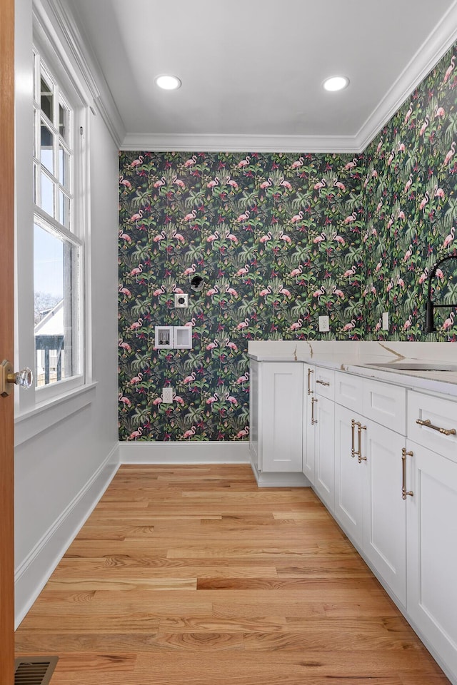 bathroom featuring wallpapered walls, baseboards, and wood finished floors