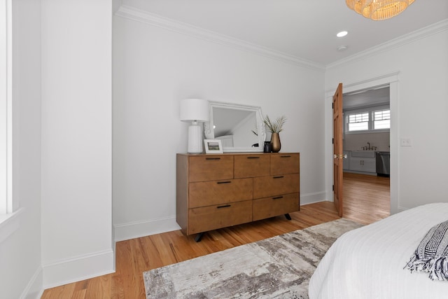 bedroom with ornamental molding, light wood-style flooring, and baseboards