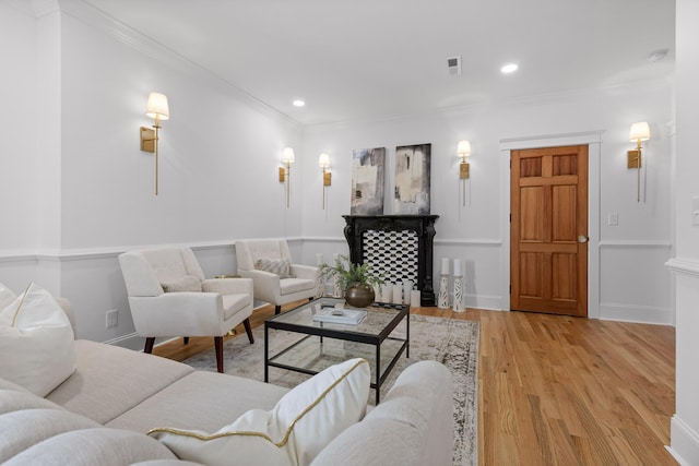 living area featuring ornamental molding, light wood-type flooring, visible vents, and recessed lighting