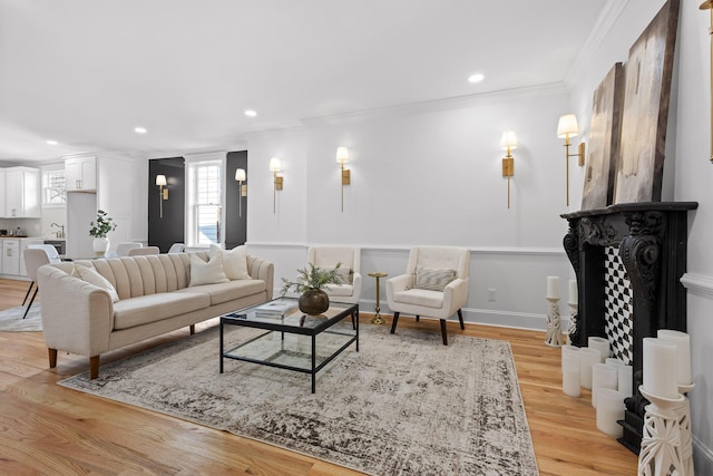 living room featuring ornamental molding, recessed lighting, light wood-style flooring, and baseboards