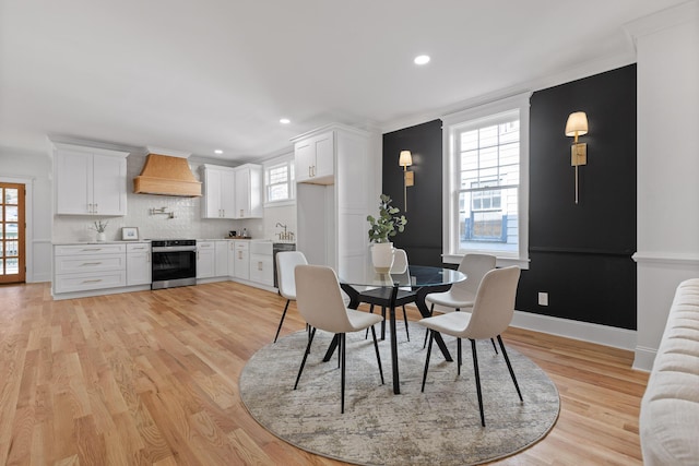 dining space with light wood finished floors, recessed lighting, and baseboards