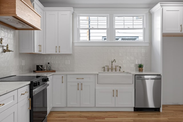 kitchen with black range with electric stovetop, white cabinets, a sink, premium range hood, and dishwasher