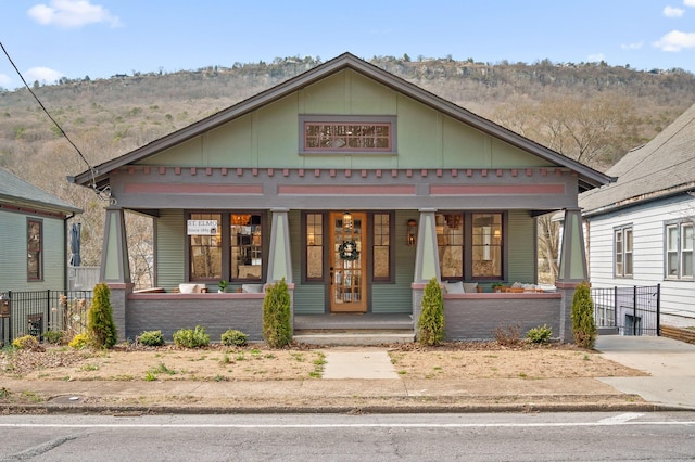 view of front facade featuring covered porch and fence