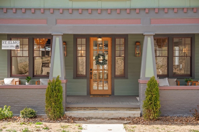 view of exterior entry featuring covered porch