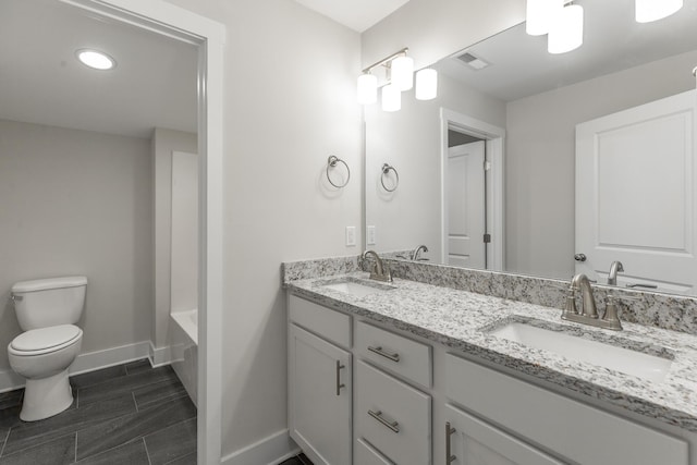 4659 Heiskell Dr, Chattanooga, TN 37416 - full bathroom with baseboards, toilet, double vanity, wood finish floors, and a bath