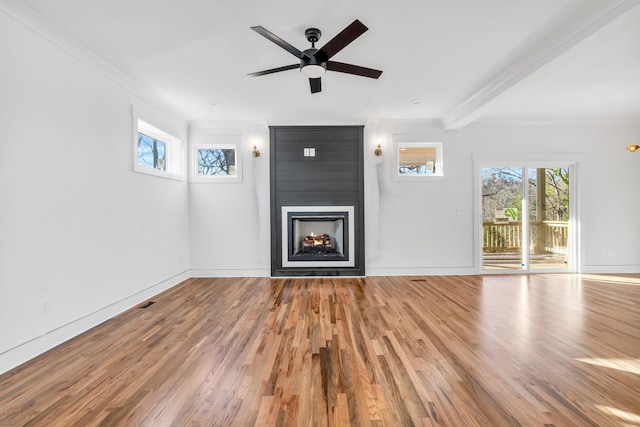 unfurnished living room featuring a healthy amount of sunlight, a fireplace, and wood finished floors