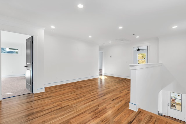 unfurnished room with baseboards, wood finished floors, and recessed lighting