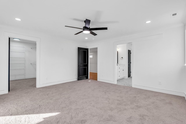 unfurnished bedroom with carpet, visible vents, a walk in closet, and recessed lighting