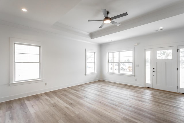 foyer with light wood-type flooring, baseboards, and a tray ceiling