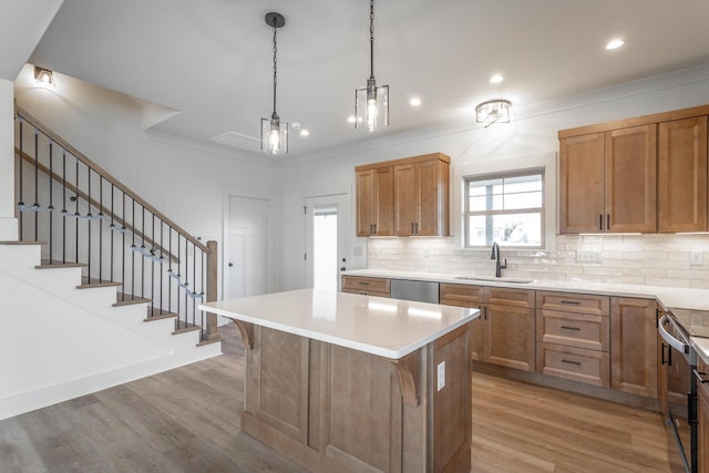 kitchen featuring light wood finished floors, appliances with stainless steel finishes, backsplash, and a sink