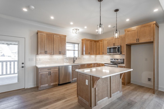 kitchen featuring tasteful backsplash, appliances with stainless steel finishes, a center island, light wood-type flooring, and a sink