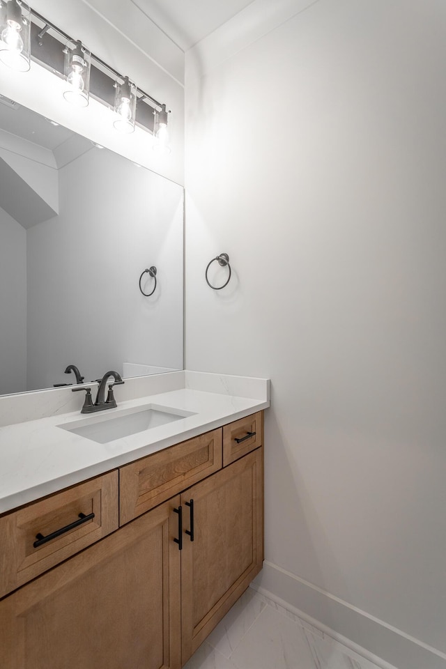 bathroom with marble finish floor, baseboards, and vanity