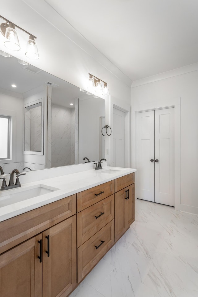 bathroom with crown molding, marble finish floor, a sink, and double vanity