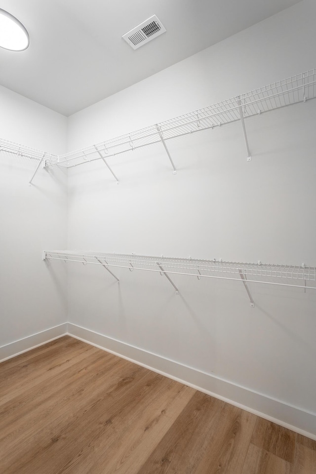 walk in closet with light wood finished floors and visible vents