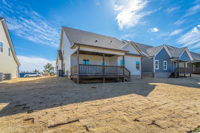 rear view of house with central AC unit and a wooden deck