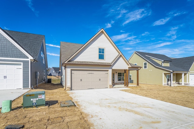 view of front of home featuring concrete driveway, roof with shingles, and an attached garage