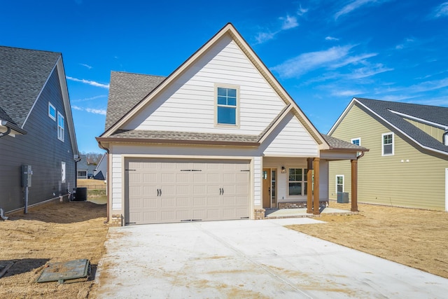 view of front of property with a garage, driveway, roof with shingles, and cooling unit