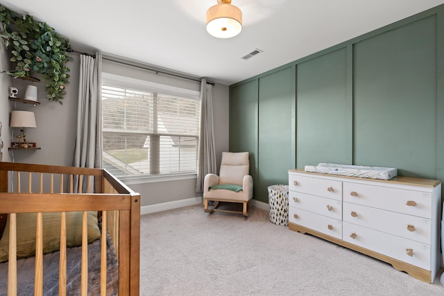 bedroom featuring a decorative wall, light carpet, visible vents, baseboards, and a closet