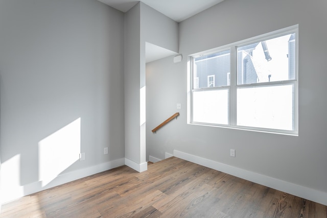 empty room with baseboards and wood finished floors