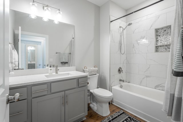 bathroom featuring toilet, shower / tub combination, wood finished floors, and vanity