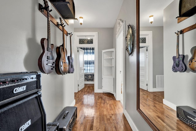 mudroom with baseboards, visible vents, and hardwood / wood-style floors