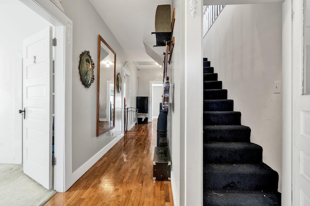 stairs with baseboards and wood finished floors