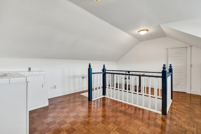 additional living space featuring lofted ceiling, washer / dryer, and baseboards