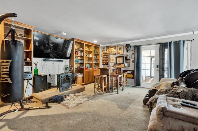 living area featuring light carpet, a bar, and a wood stove