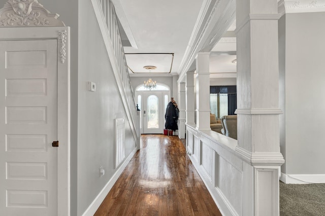 interior space with dark wood-type flooring, visible vents, baseboards, ornamental molding, and decorative columns