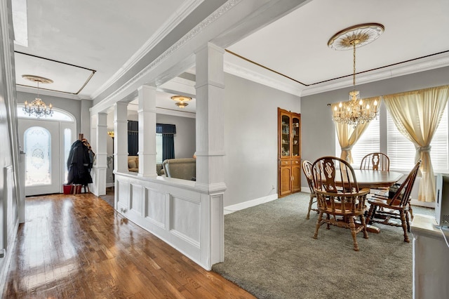 dining area featuring ornate columns, crown molding, dark wood finished floors, and a notable chandelier