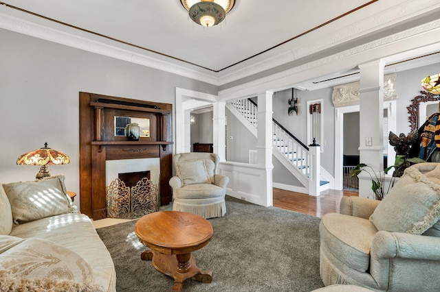 living area featuring a fireplace, stairway, ornamental molding, wood finished floors, and baseboards