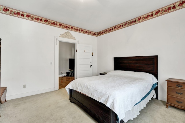 bedroom with light colored carpet and baseboards