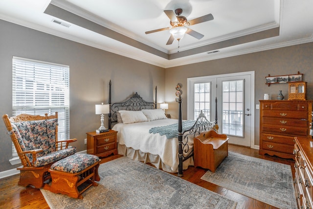 bedroom featuring a raised ceiling, visible vents, and hardwood / wood-style flooring