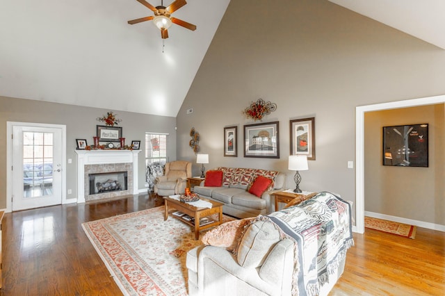 living room with a fireplace, wood finished floors, a wealth of natural light, and baseboards