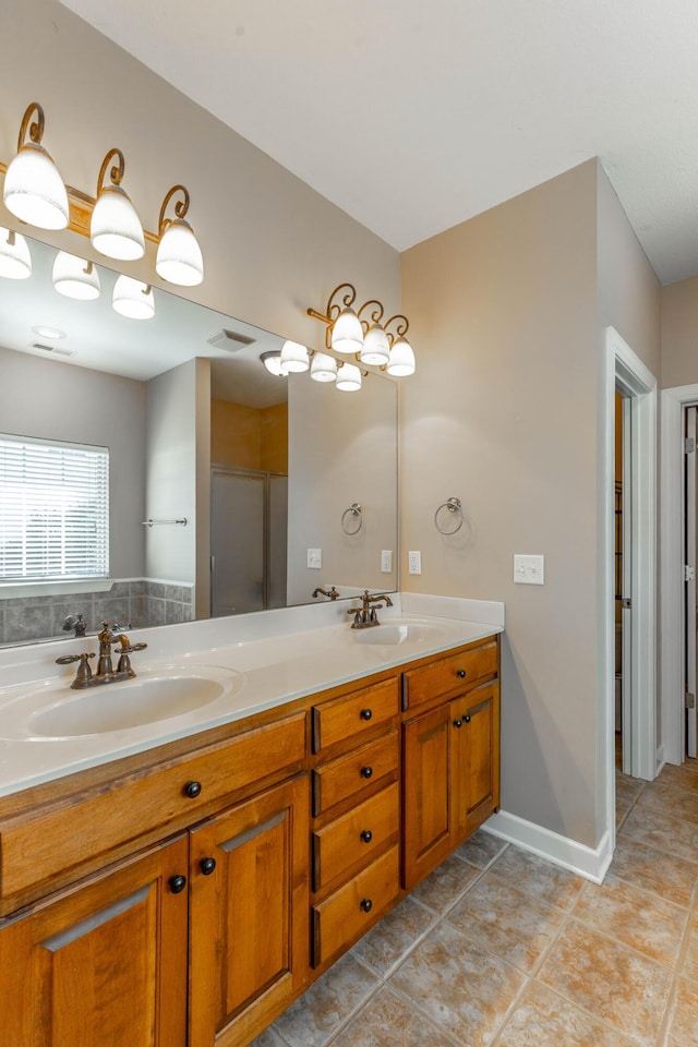 full bath featuring double vanity, tile patterned flooring, a sink, and baseboards