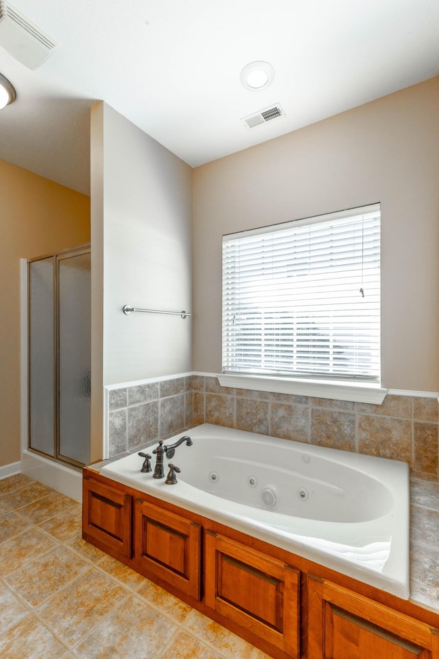 bathroom with a jetted tub, a stall shower, tile patterned flooring, and visible vents