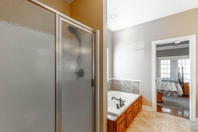 ensuite bathroom featuring connected bathroom, baseboards, a shower stall, a bath, and tile patterned floors