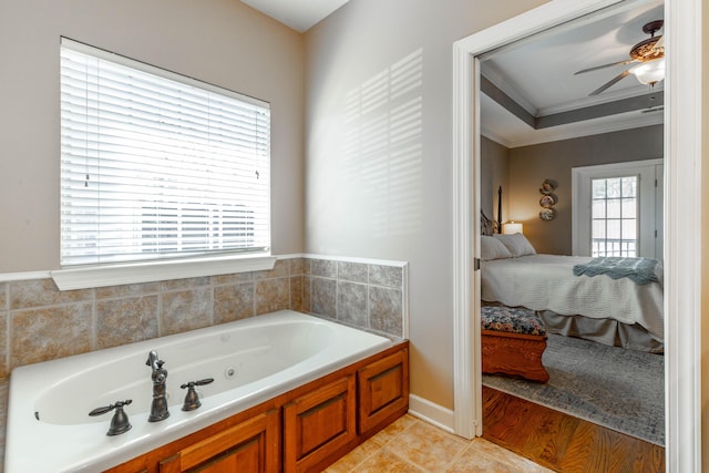 ensuite bathroom featuring ceiling fan, ensuite bath, ornamental molding, a tub with jets, and tile patterned floors