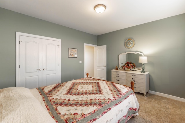 bedroom with baseboards, a closet, and light colored carpet