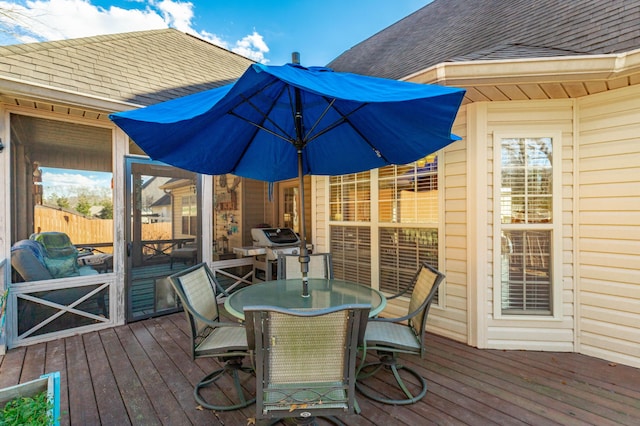 wooden deck with outdoor dining area and grilling area