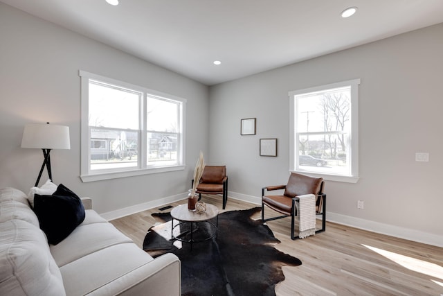 living room with light wood finished floors, baseboards, and recessed lighting