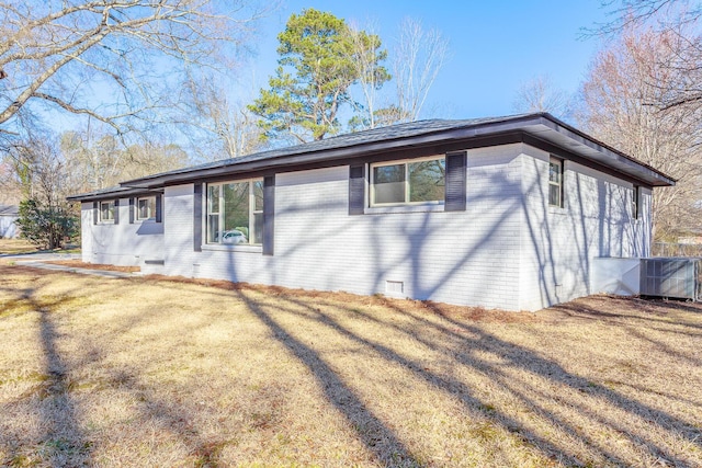 exterior space featuring a front yard, crawl space, brick siding, and central air condition unit