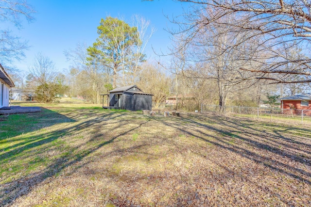 view of yard with fence and an outdoor structure