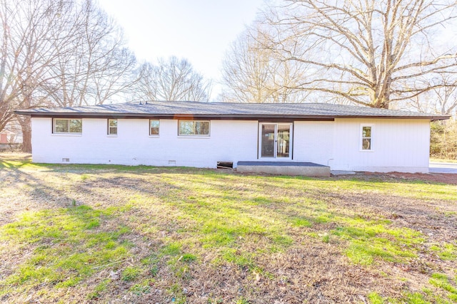 back of house with crawl space, brick siding, and a yard