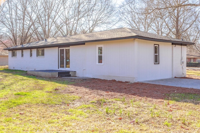 rear view of house with a patio, brick siding, and a lawn